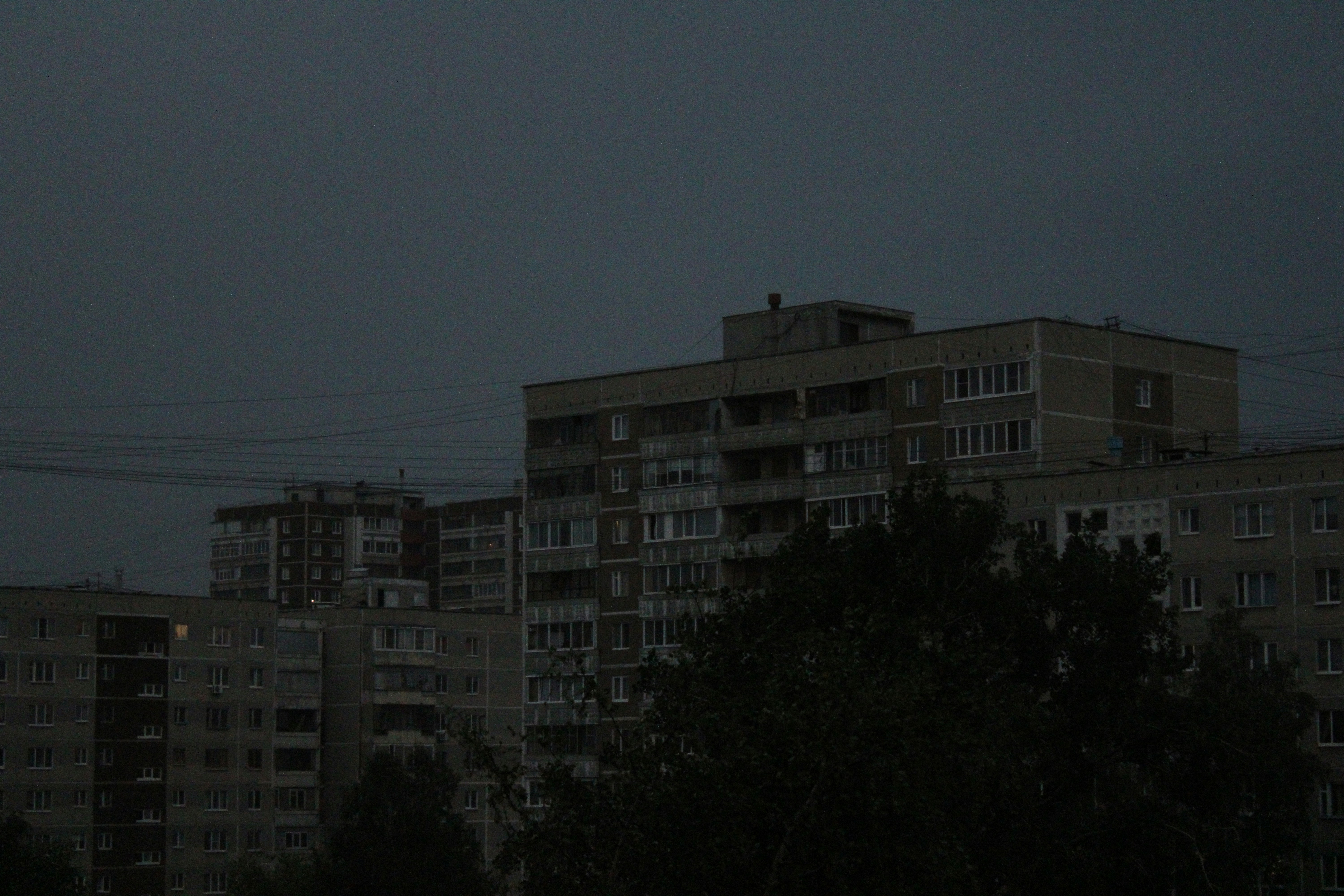 都心の高層ビル群を見下ろすルーフトップバーで、カクテルを片手に談笑する人々の姿